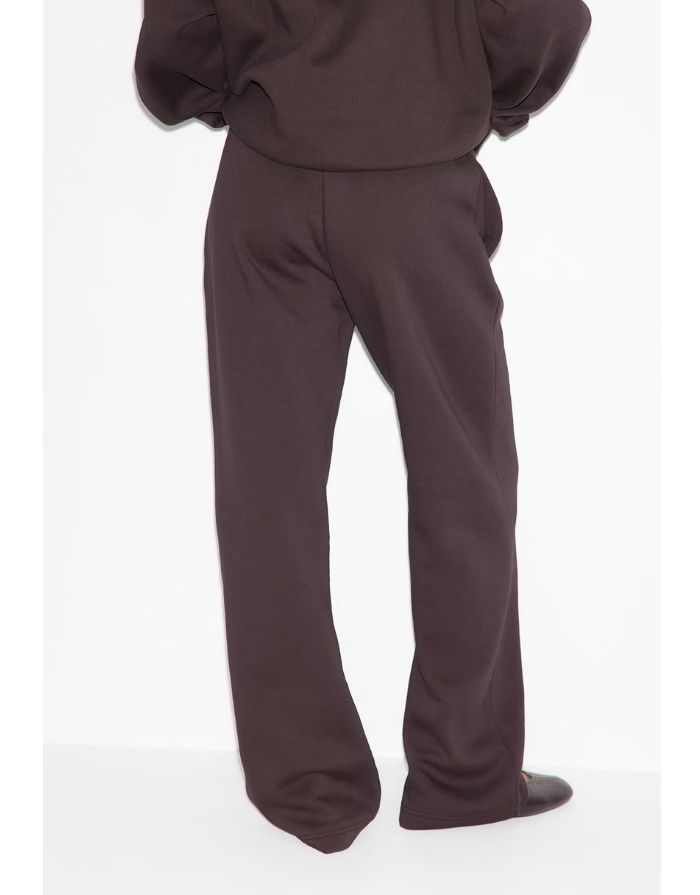 Gina Tricot Iconic Sweat Pants in Chocolate Plum aus Baumwollmischung mit weitem geradem Bein, elastischem Bund, Bindeband und Seitentaschen am Model von hinten