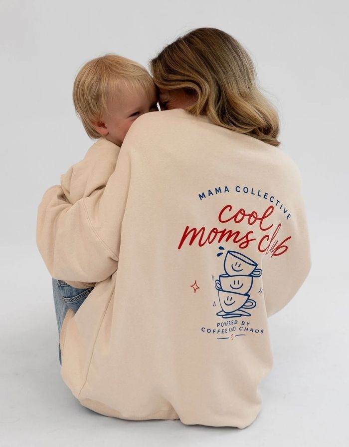 Liliput Cool Moms Club Oversize Sweatshirt für Damen mit Brustprint und großem Rückenprint mit zwei Kaffeetassen und „Powered by Coffee and Chaos“-Schriftzug, getragen.