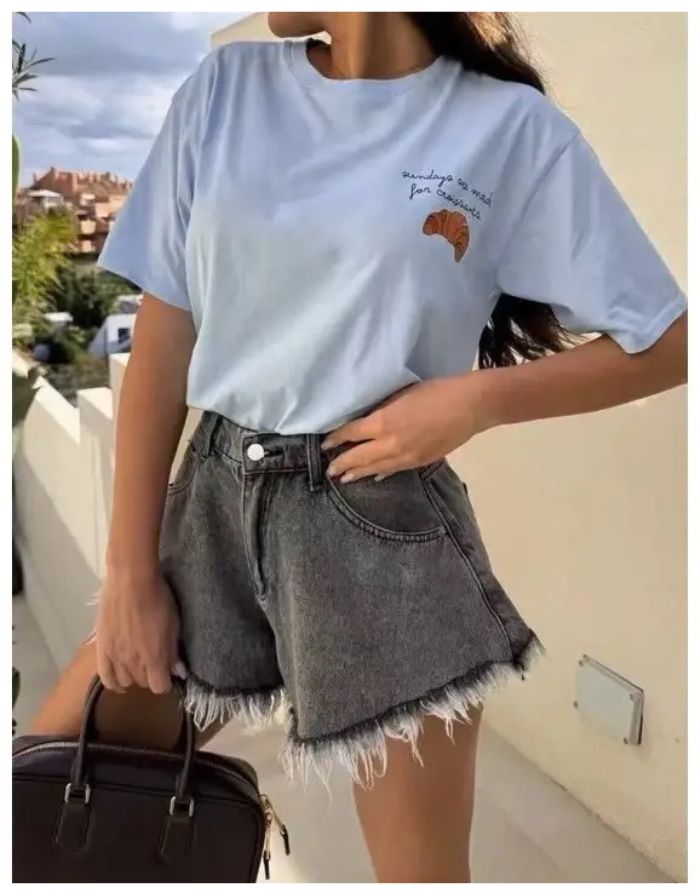 Hellblaues Baumwoll-T-Shirt von Estée Brown mit kleinem Croissant-Motiv und Schriftzug „Sundays are made for Croissants“.