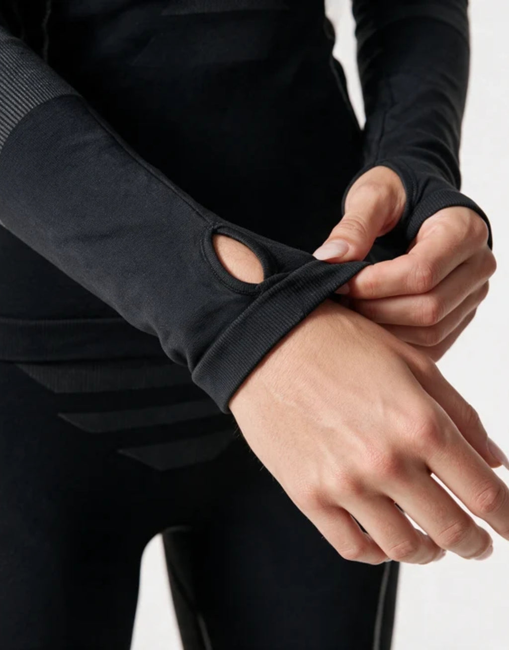 Schwarzes Thermo Longsleeve für Damen von SNOCKS aus elastischem, recyceltem Funktionsmaterial mit Raglanärmeln, Daumenlöchern und körpernaher Passform.