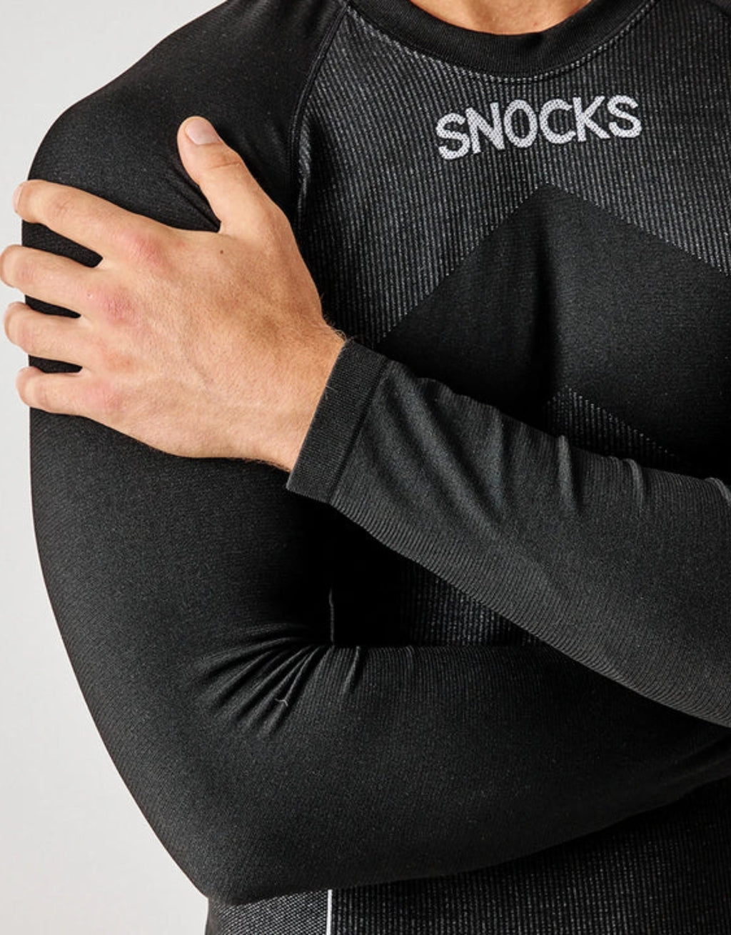 Schwarzes Thermounterhemd für Herren von SNOCKS aus elastischem, recyceltem Funktionsmaterial mit langen Ärmeln, praktischen Daumenlöchern und körpernaher Passform.