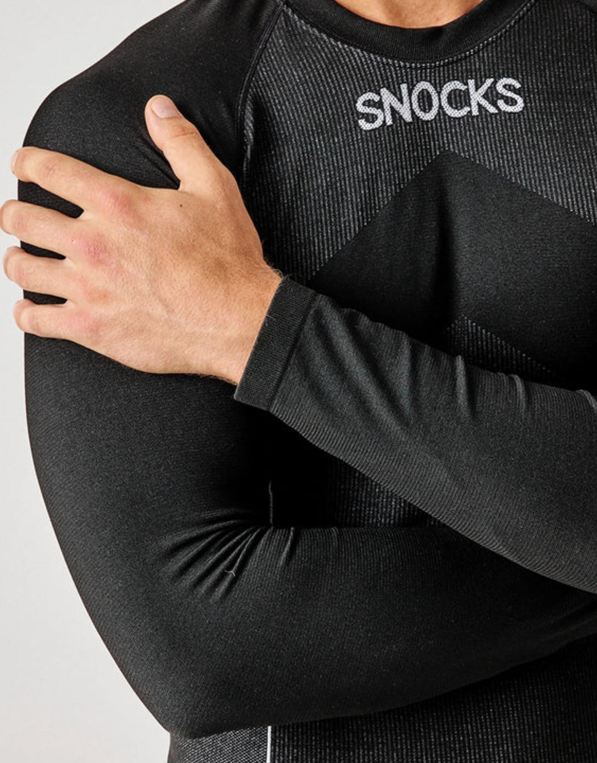 Schwarzes Thermounterhemd für Herren von SNOCKS aus elastischem, recyceltem Funktionsmaterial mit langen Ärmeln, praktischen Daumenlöchern und körpernaher Passform.