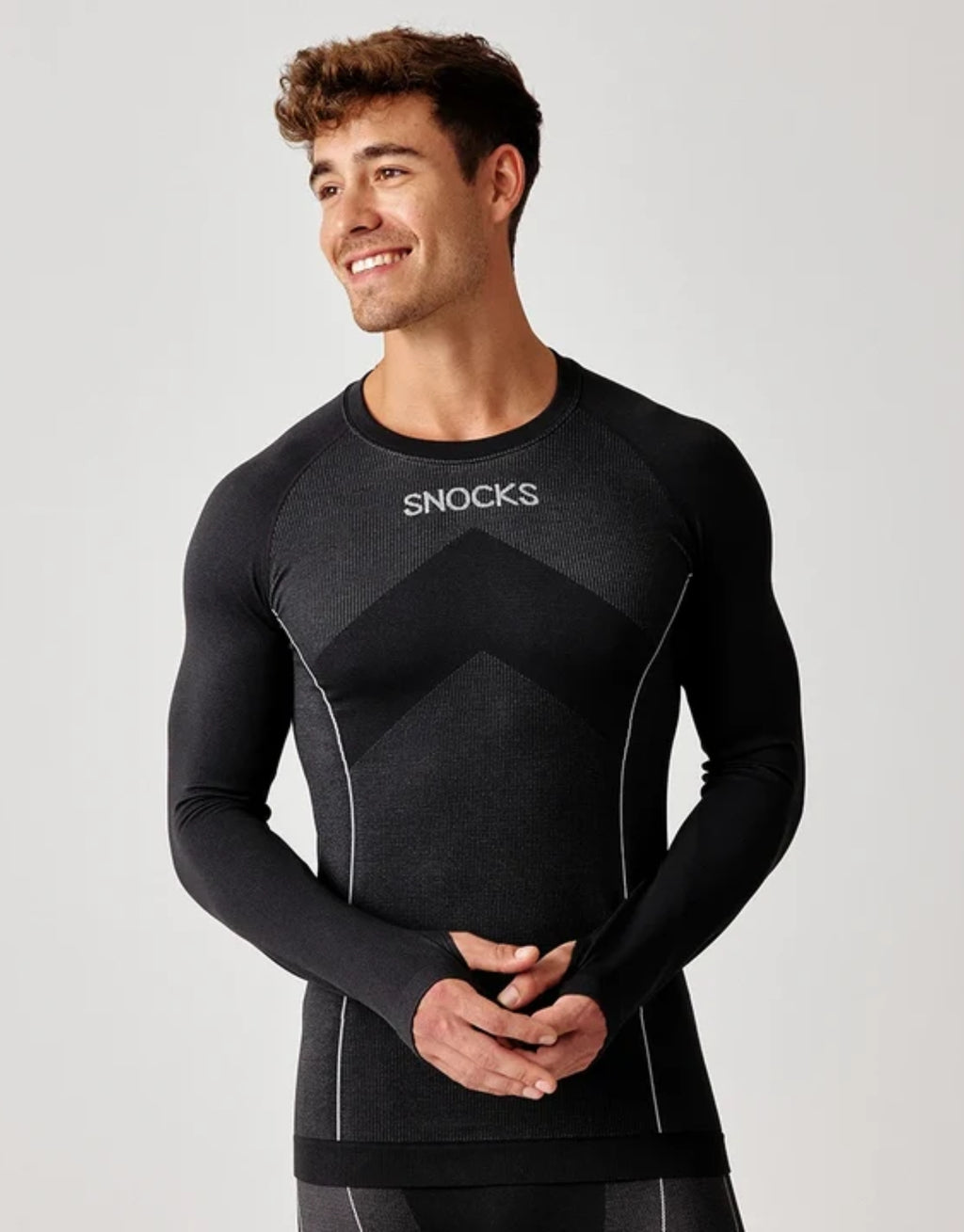 Schwarzes Thermounterhemd für Herren von SNOCKS aus elastischem, recyceltem Funktionsmaterial mit langen Ärmeln, praktischen Daumenlöchern und körpernaher Passform.