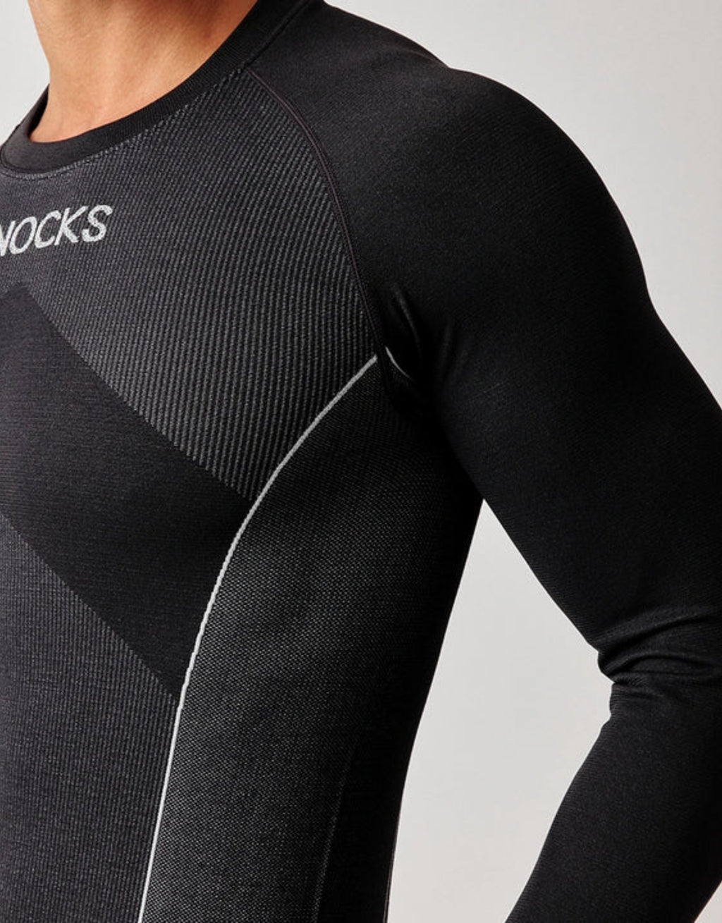 Schwarzes Thermounterhemd für Herren von SNOCKS aus elastischem, recyceltem Funktionsmaterial mit langen Ärmeln, praktischen Daumenlöchern und körpernaher Passform.