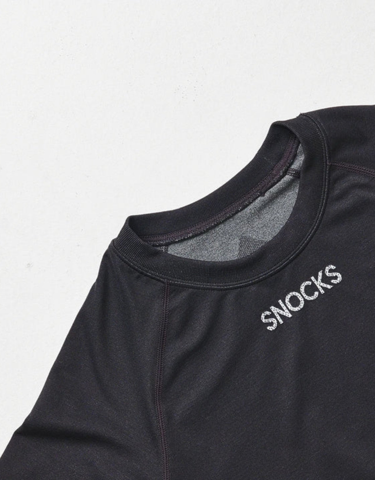 Schwarzes Thermounterhemd für Herren von SNOCKS aus elastischem, recyceltem Funktionsmaterial mit langen Ärmeln, praktischen Daumenlöchern und körpernaher Passform.