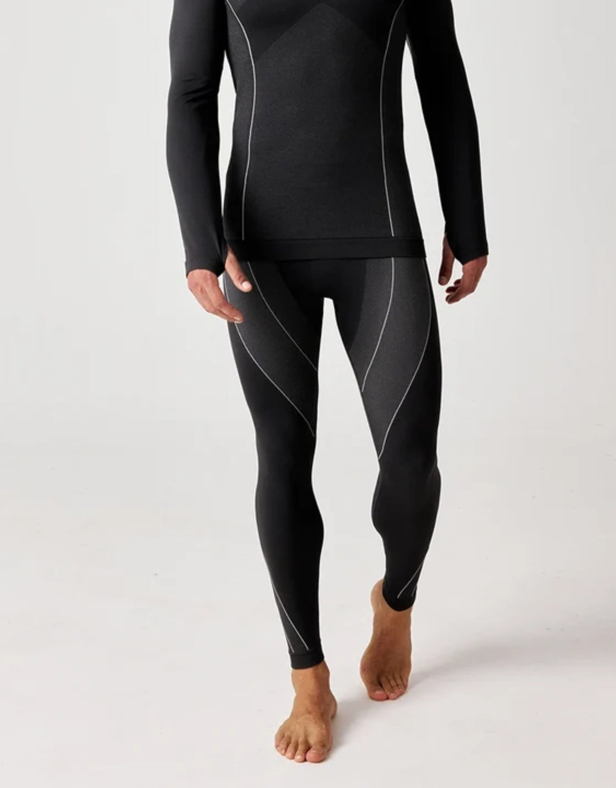 Schwarze Thermounterhose für Herren von SNOCKS aus elastischem, recyceltem Funktionsmaterial mit körpernaher Passform für angenehme Wärme an kalten Tagen, am Model.