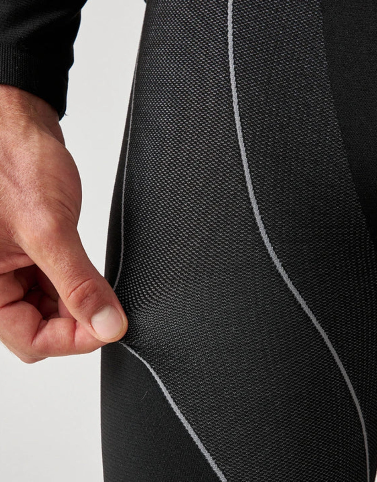 Schwarze Thermounterhose für Herren von SNOCKS aus elastischem, recyceltem Funktionsmaterial mit körpernaher Passform für angenehme Wärme an kalten Tagen, Nahaufnahme.