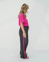 Laden Sie das Bild in den Galerie-Viewer, OH APRIL Trackpants Kael Leo Grey – weite Damenhose mit rosa Seitenstreifen, Leo-Muster, Wide Leg Fit, Größen XS–XL.
