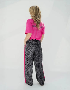 OH APRIL Trackpants Kael Leo Grey – weite Damenhose mit rosa Seitenstreifen, Leo-Muster, Wide Leg Fit, Größen XS–XL.
