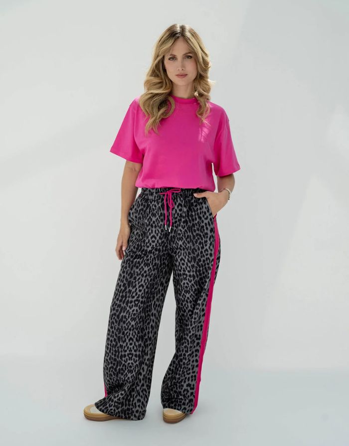 OH APRIL Trackpants Kael Leo Grey – weite Damenhose mit rosa Seitenstreifen, Leo-Muster, Wide Leg Fit, Größen XS–XL.