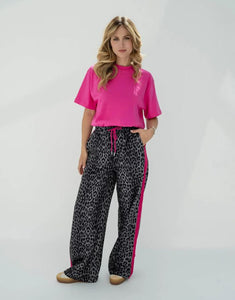 OH APRIL Trackpants Kael Leo Grey – weite Damenhose mit rosa Seitenstreifen, Leo-Muster, Wide Leg Fit, Größen XS–XL.