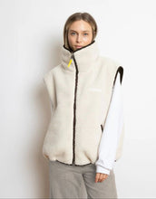 Laden Sie das Bild in den Galerie-Viewer, Reversible Bomber Weste von Vivi Mari in Chocolate Sand  tragbar mit glattem Nylon oder weichem Fleece außen, oversized geschnitten mit Reißverschluss und Taschen, ideal für Layering und urbane Looks.
