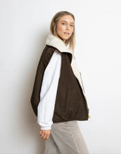 Laden Sie das Bild in den Galerie-Viewer, Reversible Bomber Weste von Vivi Mari in Chocolate Sand  tragbar mit glattem Nylon oder weichem Fleece außen, oversized geschnitten mit Reißverschluss und Taschen, ideal für Layering und urbane Looks.

