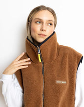 Laden Sie das Bild in den Galerie-Viewer, Reversible Bomber Weste von Vivi Mari in Navy und Karamell, tragbar mit glattem Nylon oder weichem Fleece außen, oversized geschnitten mit Reißverschluss und Taschen, ideal für Layering und urbane Looks.
