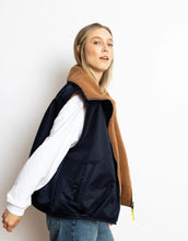 Laden Sie das Bild in den Galerie-Viewer, Reversible Bomber Weste von Vivi Mari in Navy und Karamell, tragbar mit glattem Nylon oder weichem Fleece außen, oversized geschnitten mit Reißverschluss und Taschen, ideal für Layering und urbane Looks.

