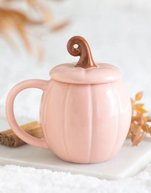 Pinker Kürbisbecher von Something Different mit passendem Deckel und geschwungenem Stiel, 450 ml, für herbstliche Heißgetränke auf einer Marmorplatte 