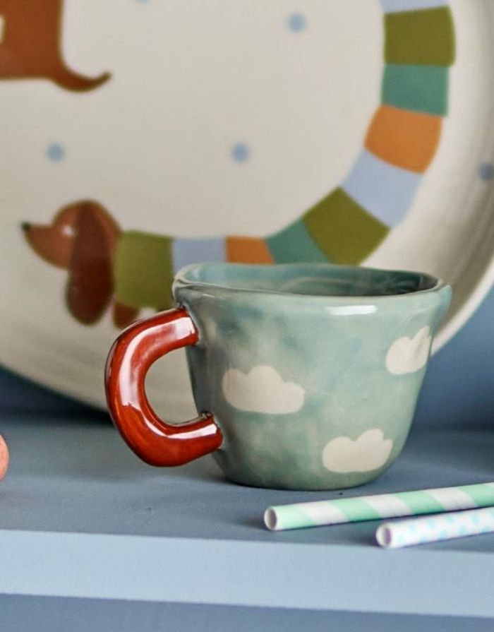 Blaue Tasse Nini von Bloomingville MINI aus Steingut mit handgemaltem Wolkenmotiv und 110 ml Fassungsvermögen.