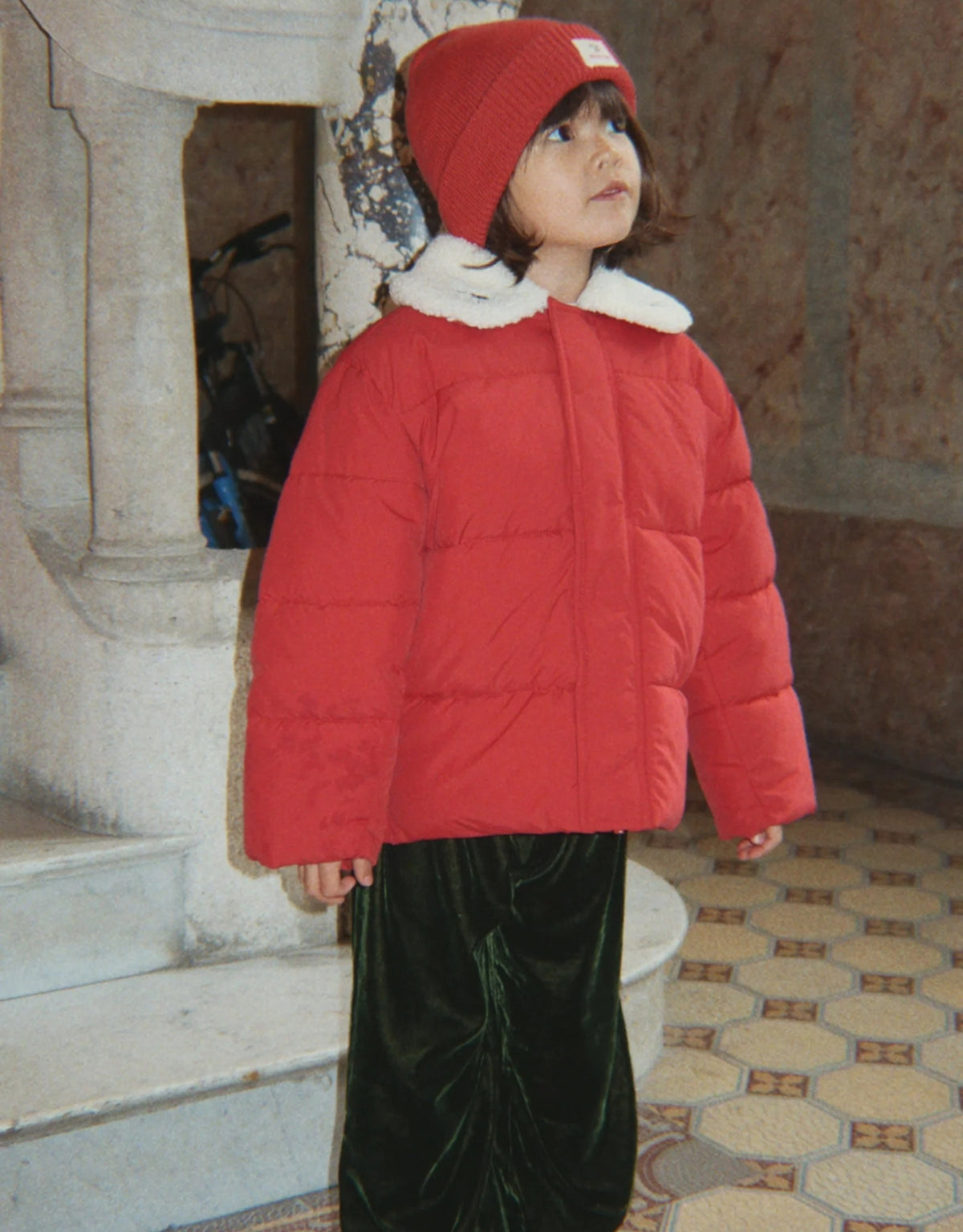 Avely Beanie von Konges Sløjd in der Farbe Cardinal aus weicher Bio-Baumwolle mit klassischer Rippstrickstruktur und verstellbarem Umschlag, am Model von vorne.