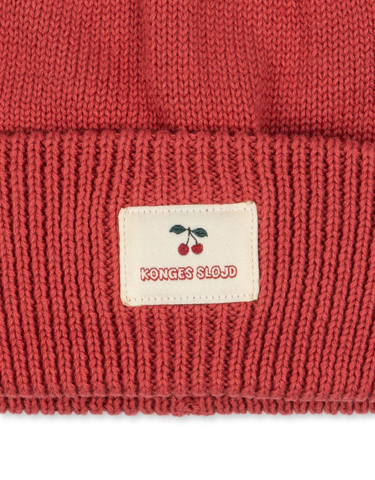 Avely Beanie von Konges Sløjd in der Farbe Cardinal aus weicher Bio-Baumwolle mit klassischer Rippstrickstruktur und verstellbarem Umschlag, Nahaufnahme.