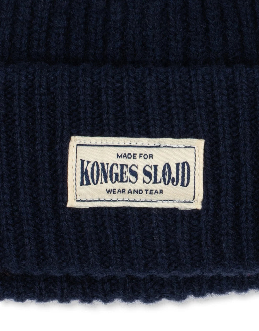 Dunkelblaue Basil Beanie von Konges Sløjd in der Farbe Total Eclipse aus 100 % Wolle mit klassischer Rippstrickstruktur und verstellbarem Umschlag, Logo.