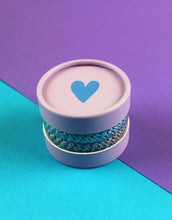Laden Sie das Bild in den Galerie-Viewer, Ava &amp; Yves Haargummi-Set Flieder/Blau – 4 elastische Haargummis mit Schimmer in runder Geschenkbox.
