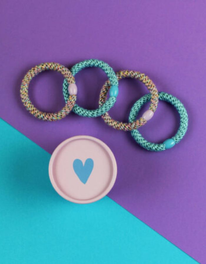 Ava & Yves Haargummi-Set Flieder/Blau – 4 elastische Haargummis mit Schimmer in runder Geschenkbox.