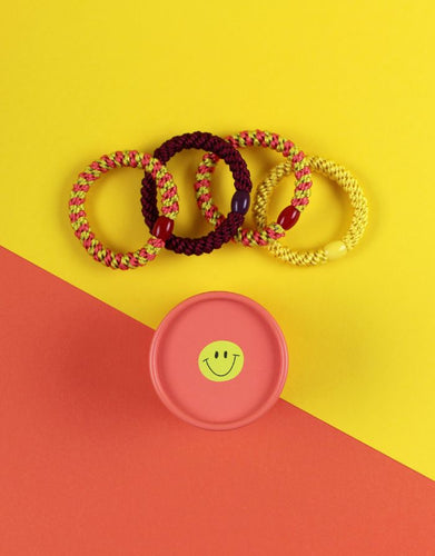 Ava & Yves Haargummi-Set Koralle/Gelb – 4 elastische Haargummis in runder Geschenkbox mit Smiley.