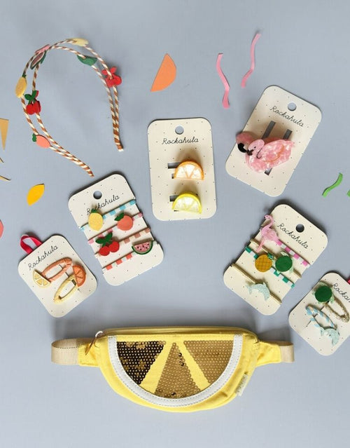 Tutti Fruity Haarspangen von Rockahula im 4er-Set mit glitzernden Zitronen-, Orangen-, Kirsch- und Wassermelonenmotiven auf bunten Klickspangen.
