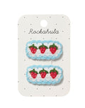  Crochet Strawberry Frill Haarspangen von Rockahula mit gehäkelten Erdbeeren, blauem Wellenrand und stoffbezogenen Klickspangen.