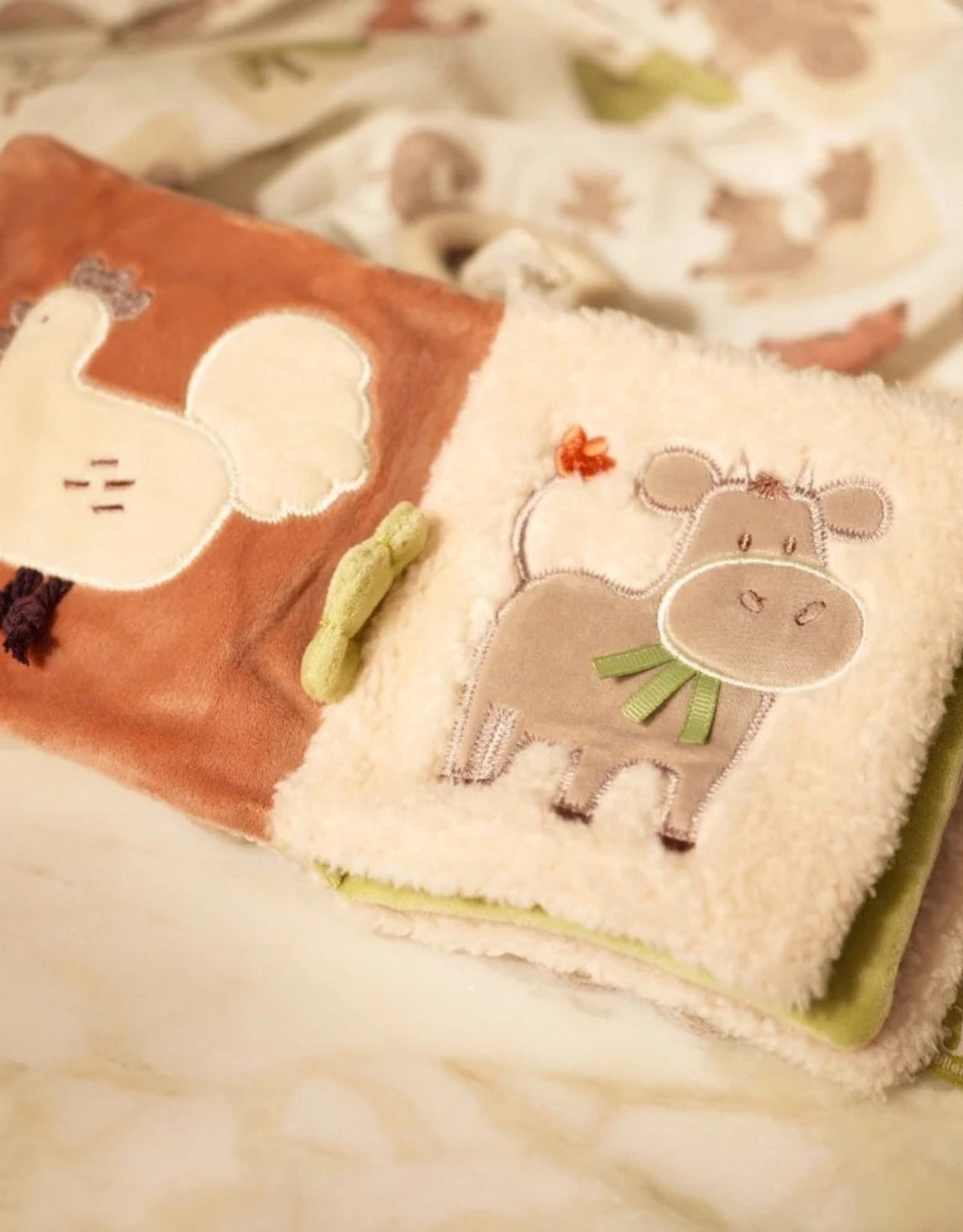 Weiches Stoffbuch Barn Buddies von Jollein mit Bauernhoftieren, Knisterelementen, Fühl-Labels, aufklappbaren Laschen und Spiegel für Babys geöffnet auf Krabbeldecke