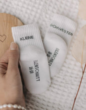 Laden Sie das Bild in den Galerie-Viewer, Babysocken Kleine Schwester von Eulenschnitt, 80% Baumwolle, 18% Polyamid, 2% Elastan, mit Schriftzug „Kleine Schwester“ auf dem Bündchen.
