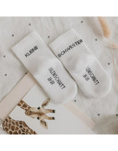 Laden Sie das Bild in den Galerie-Viewer, Babysocken Kleine Schwester von Eulenschnitt, 80% Baumwolle, 18% Polyamid, 2% Elastan, mit Schriftzug „Kleine Schwester“ auf dem Bündchen.
