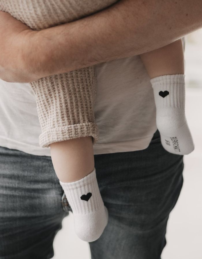Weiße Babysocken Herz Schwarz von Eulenschnitt mit eingesticktem schwarzem Herz und weicher Baumwollqualität für Babys.