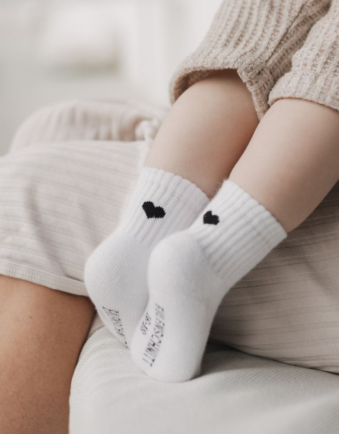 Weiße Babysocken Herz Schwarz von Eulenschnitt mit eingesticktem schwarzem Herz und weicher Baumwollqualität für Babys.