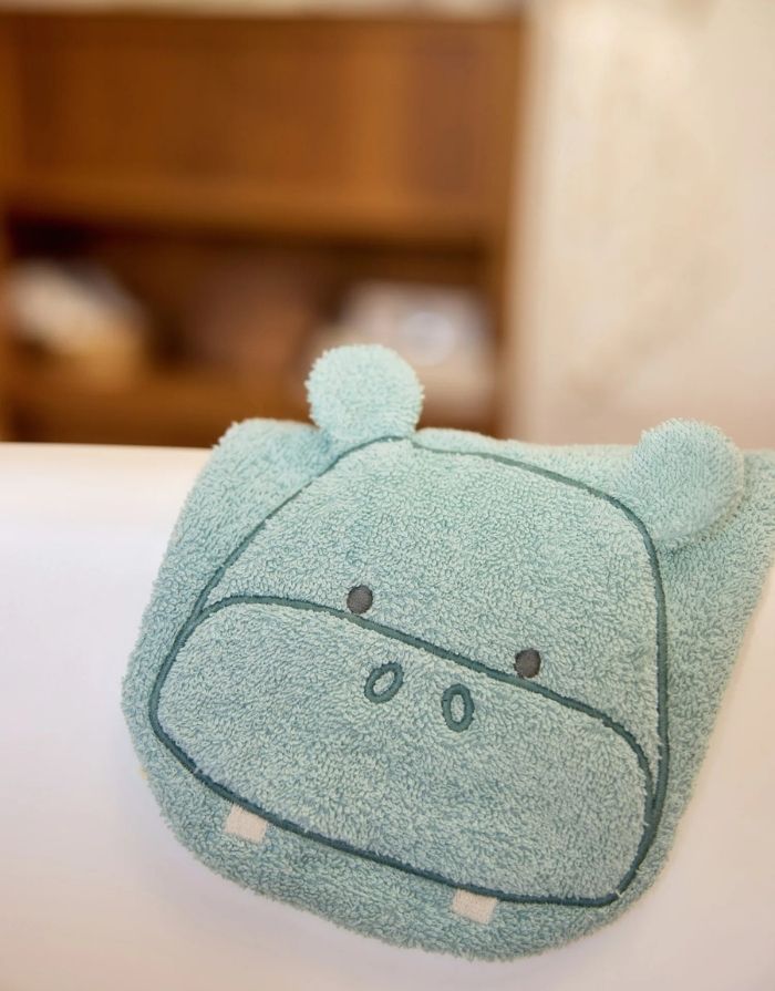 Weicher Frottee-Waschlappen Waschhandschuhe Hippo Happy von Jollein für Babys aus Baumwollfrottier mit niedlichem Nilpferd-Design über einer Lehne