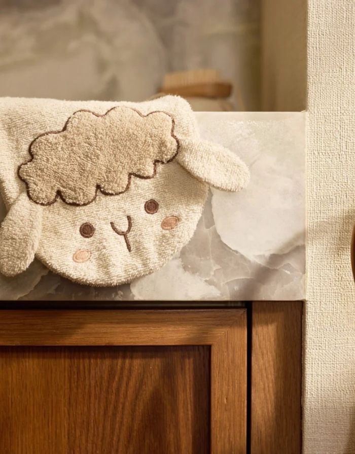 Weicher Frottee-Waschlappen Sheep Sonny von Jollein für Babys aus Baumwollfrottier mit niedlichem Schäfchen-Design übe reinem Waschbecken