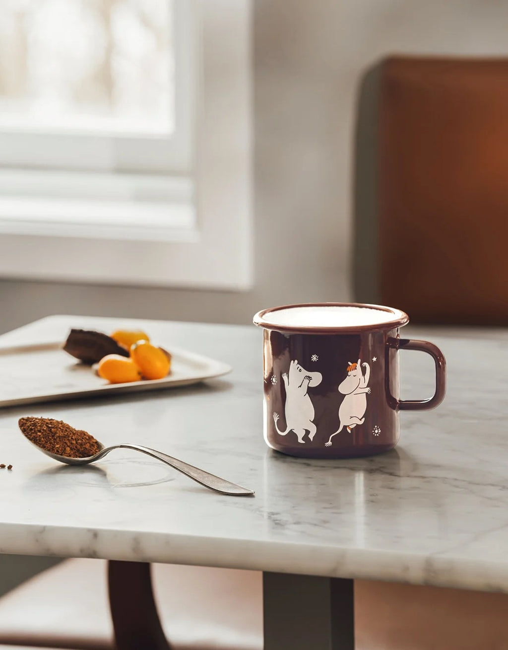 Moomin Emaille-Becher Komet von Muurla mit liebevollem Motiv aus der Geschichte „Komet im Mumintal“, dekorativer Trinkbecher aus emailliertem Stahl mit Henkel und 550 ml Fassungsvermögen auf einem Tisch
