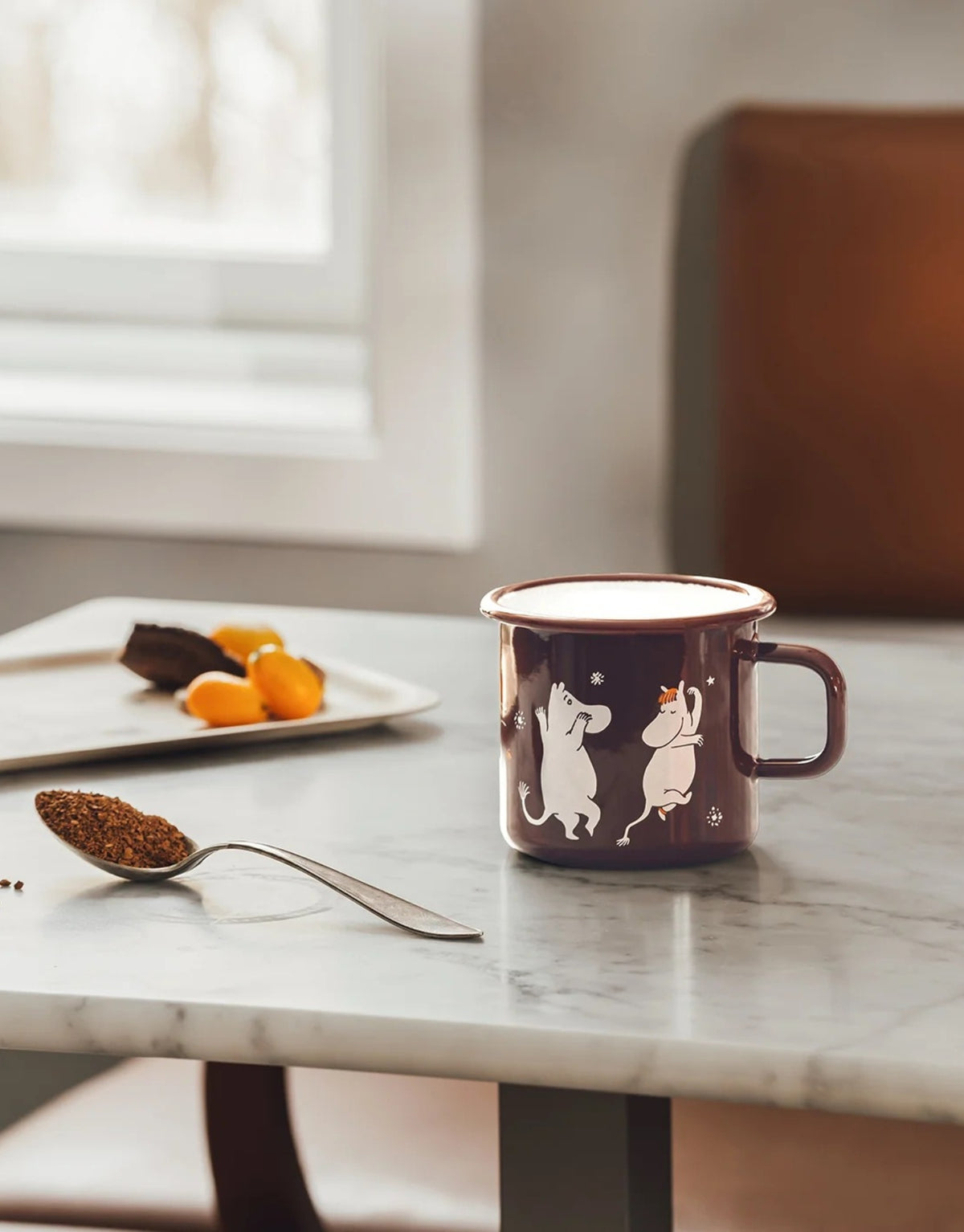 Moomin Emaille-Becher Komet von Muurla mit liebevollem Motiv aus der Geschichte „Komet im Mumintal“, dekorativer Trinkbecher aus emailliertem Stahl mit Henkel und 550 ml Fassungsvermögen auf einem Tisch