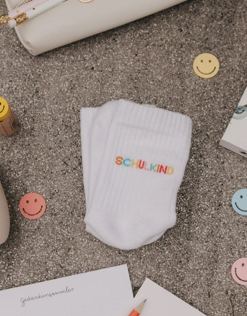 Weiße Eulenschnitt Socken „Schulkind“ mit buntem Schriftzug auf der Ferse und weichen Bündchen für Kinder