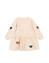 Laden Sie das Bild in den Galerie-Viewer, Beige Lou Sweat Dress von Konges Sløjd mit bunten Herz-Patches, ausgestelltem Rock und Rundhalsausschnitt.
