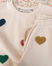 Laden Sie das Bild in den Galerie-Viewer, Beige-rosefarbene Lou Sweatpants von Konges Sløjd mit bunten Herzen und elastischem Bund.
