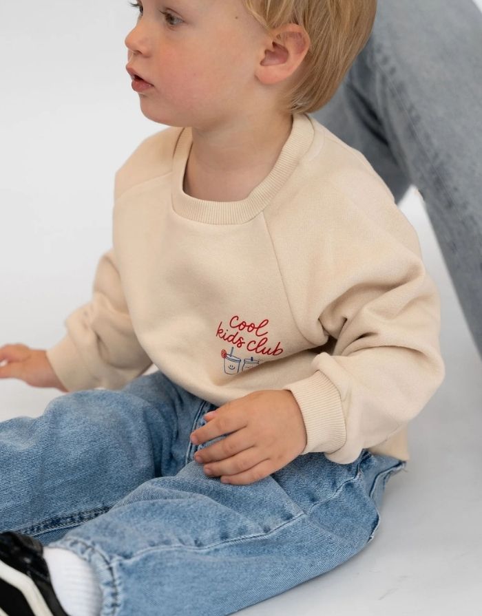 Liliput Oversize Sweatshirt Cool Kids Club für Kinder mit Frontprint und großem „Powered by Vitamins &Adventure“-Rückenprint, am Model.