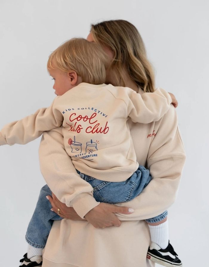 Liliput Oversize Sweatshirt Cool Kids Club für Kinder mit Frontprint und großem „Powered by Vitamins &Adventure“-Rückenprint, am Model.