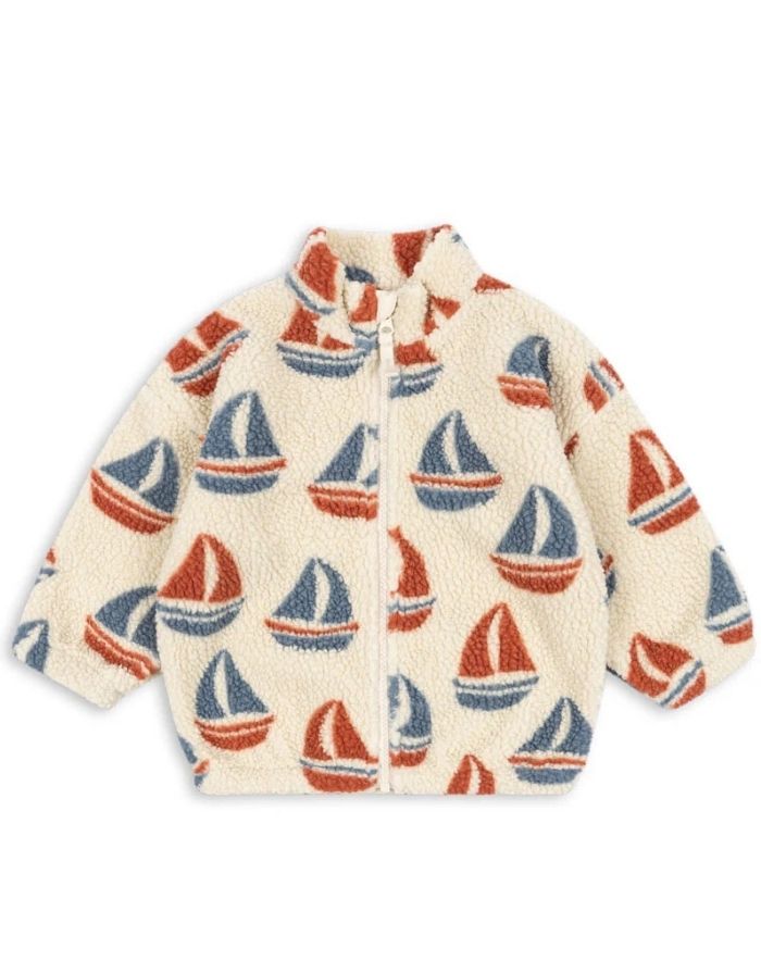 Die Teddyjacke Jody Ahoy von Konges Sløjd ist ein kuscheliger Begleiter für kalte Tage und aktive Abenteuer im Freien. Das weiche Teddy-Material aus recyceltem Polyester hält angenehm warm, während das innenliegende Fleece für zusätzlichen Komfort sorgt. Mit ihrem hohen Kragen schützt die Jacke zuverlässig vor Wind, und die elastischen Ärmelbündchen sorgen für einen guten Sitz. Der durchgehende Frontreißverschluss macht das An- und Ausziehen besonders einfach – ideal für den Alltag mit Kindern. Das Ahoy-Des