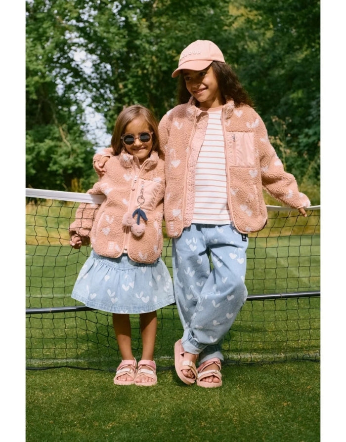 Liewood Kinderjeans Borris in Sweetheart Light Blue Denim mit lockerem Schnitt, geschwungenem Bein und verspieltem Sweetheart-Print an einem Kind mit Fleecejacke
