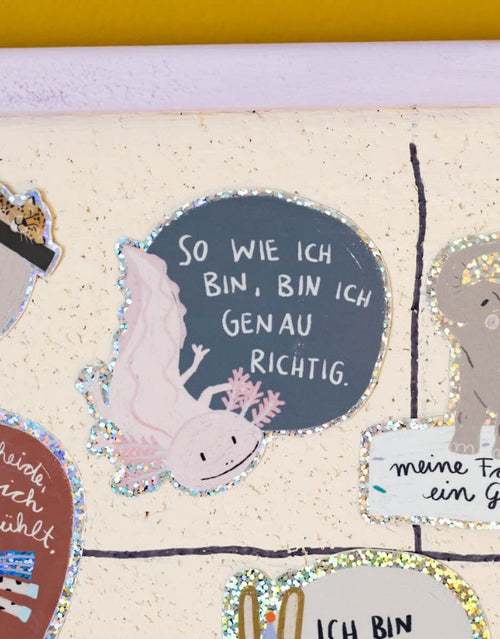 Glitzersticker von Liesels Wicht mit liebevollem Motiv und motivierender Botschaft für Kinder auf glänzendem Glitzervinyl vor einer Wand.