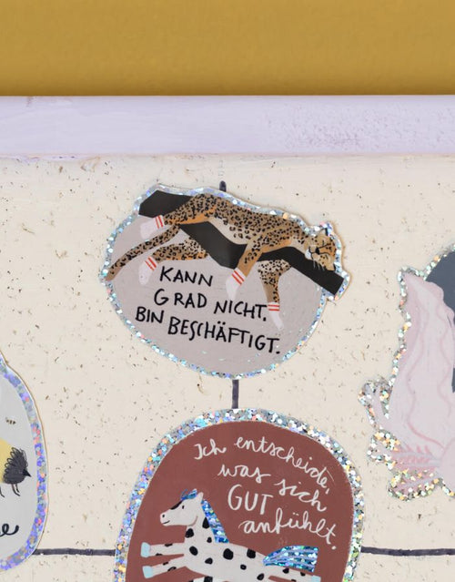 Glitzersticker von Liesels Wicht mit liebevollem Motiv und motivierender Botschaft für Kinder auf glänzendem Glitzervinyl auf einer Wand.
