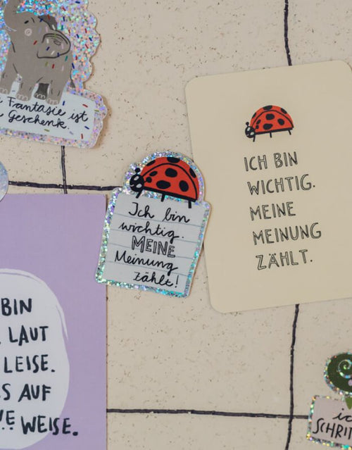 Glitzersticker von Liesels Wicht mit liebevollem Motiv und motivierender Botschaft für Kinder auf glänzendem Glitzervinyl auf einer Wand.