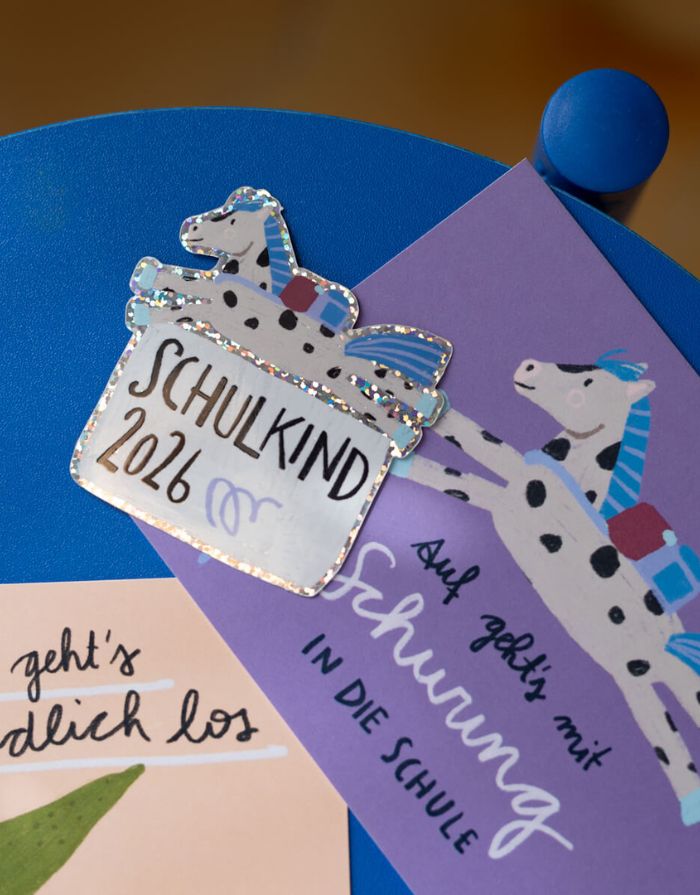 Glitzersticker von Liesels Wicht mit liebevollem Motiv und motivierender Botschaft für Kinder auf glänzendem Glitzervinyl neben einer Karte.