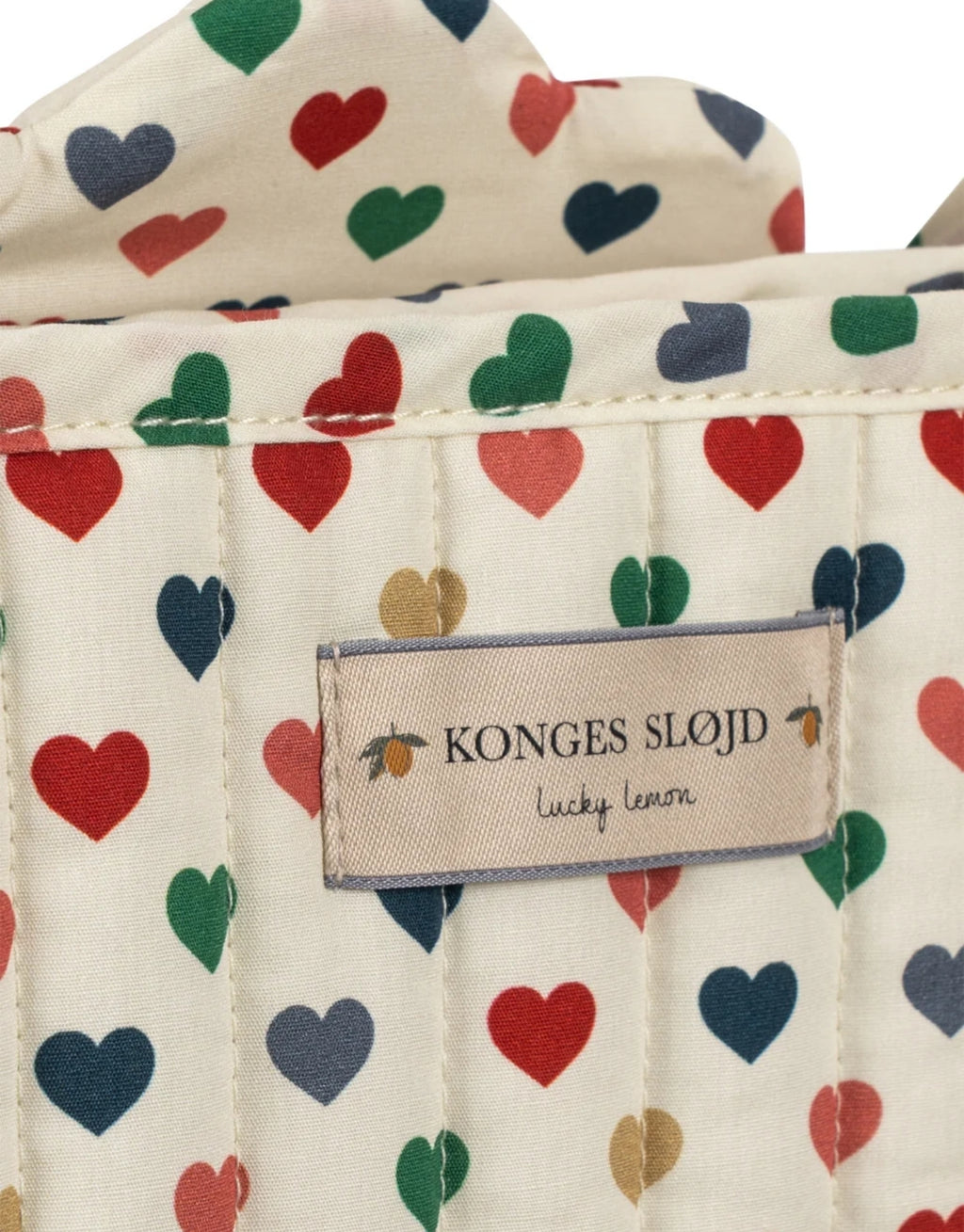  Puppenwagen Coeur Coloré von Konges Sløjd mit Herzmuster, Wagentasche, gepolsterten Griffen und Doppelrädern.